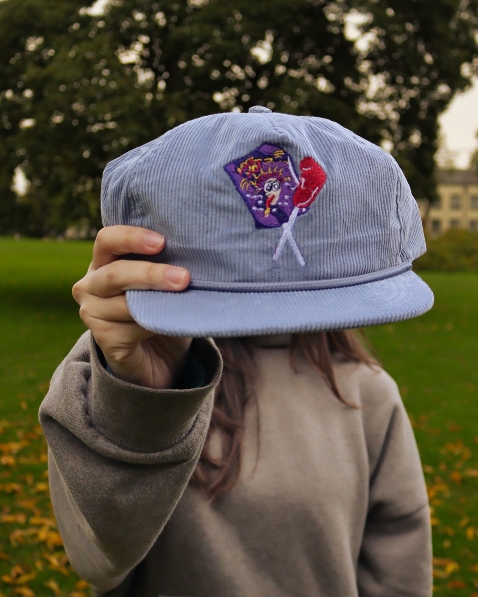 Model mengenakan hoodie Frada dan menampilkan topi Frada